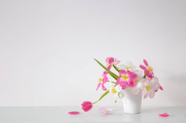 Beyaz vazoda beyaz ve pembe laleler arka plan duvarında