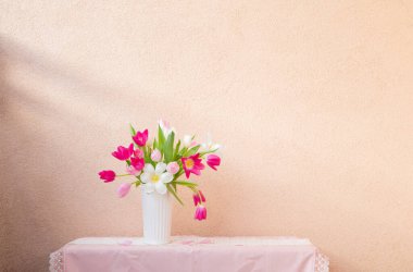 Vazodaki laleler arkaplan duvarındaki masada.