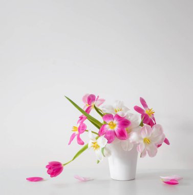 Beyaz vazoda beyaz ve pembe laleler arka plan duvarında