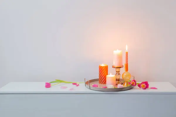 背景墙上的粉红郁金香和烤着的蜡烛 — 图库照片
