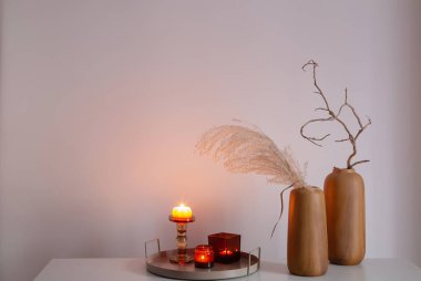 Kurumuş çiçekler ve yanan mumlarla ev dekoru.