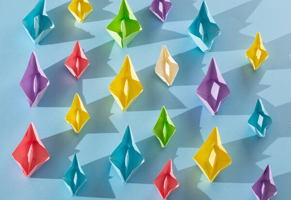 color paper boats on blue background