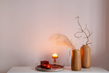 Kurumuş çiçekler ve yanan mumlarla ev dekoru.