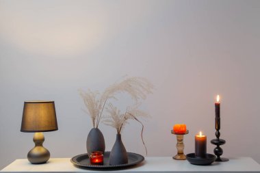 Kurumuş çiçekler ve yanan mumlarla ev dekoru.