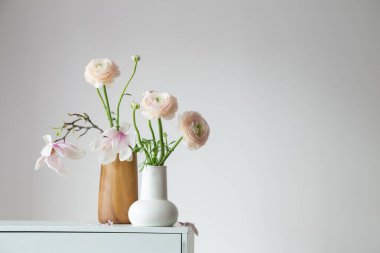 Beyaz, modern iç kısımda vazolarda bahar çiçekleri