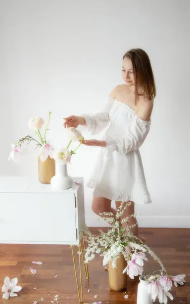 Mladá Elegantní Žena Bílých Šatech Jarní Květiny Vázách Bílém Pokoji Stock Obrázky