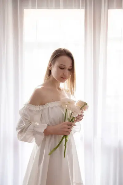 Młoda Elegancka Kobieta Białej Sukience Wiosennymi Kwiatami Wazonie Tle Okna Obrazy Stockowe bez tantiem