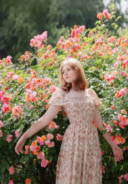 Parkta gülleri olan güzel bir kadın.