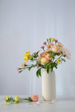 Güneş ışığında beyaz vazoda güzel bir buket