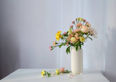 Güneş ışığında beyaz vazoda güzel bir buket