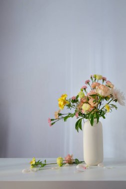 Güneş ışığında beyaz vazoda güzel bir buket