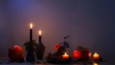 Arka plandaki ahşap rafta mumlar olan sonbahar karanlık dekoru