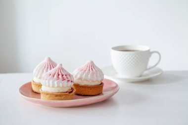 Kekler beyaz masada bir fincan kahve ile