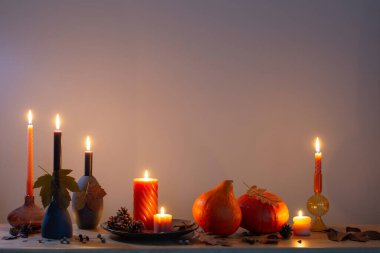 Arka plandaki ahşap rafta mumlar olan sonbahar karanlık dekoru