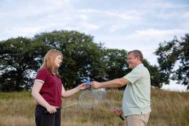 father and daughter playing badminton outdoor clipart