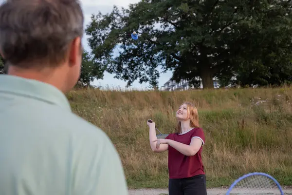 stock image father and daughter playing badminton outdoor