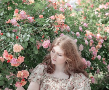 Parkta gülleri olan güzel bir kadın.