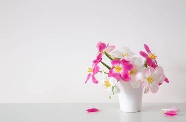 Beyaz vazoda beyaz ve pembe laleler arka plan duvarında