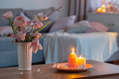 Bahar çiçekleri ve yanan mumlarla dolu bir ev.