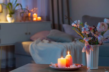 Bahar çiçekleri ve yanan mumlarla dolu bir ev.