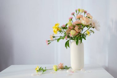 Güneş ışığında beyaz vazoda güzel bir buket