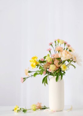 Güneş ışığında beyaz vazoda güzel bir buket