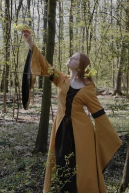 Ortaçağ elbiseli genç kadın bahar ormanında
