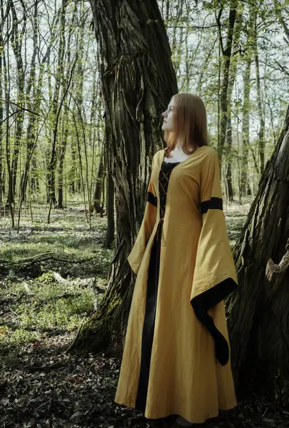 Ortaçağ elbiseli genç kadın bahar ormanında