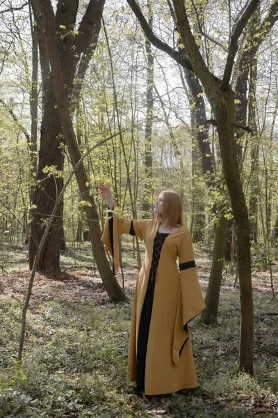 Ortaçağ elbiseli genç kadın bahar ormanında