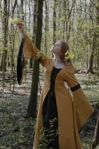 Ortaçağ elbiseli genç kadın bahar ormanında