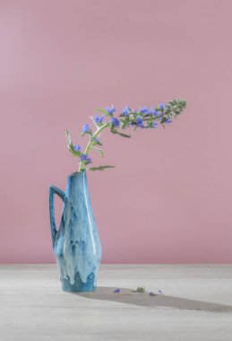 Mavi sürahi içindeki mavi yabani çiçek ahşap masada