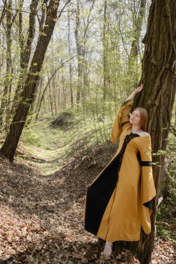 Ortaçağ elbiseli genç kadın bahar ormanında