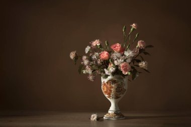 Koyu arkaplanda seramik vazoda yaz çiçekleri