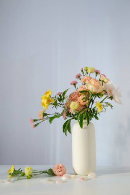 Güneş ışığında beyaz vazoda güzel bir buket