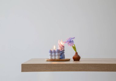 Ahşap masada yanan mumlarla mavi gözler.