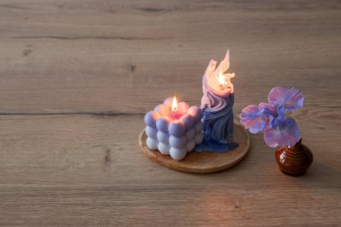 Ahşap masada yanan mumlarla mavi gözler.