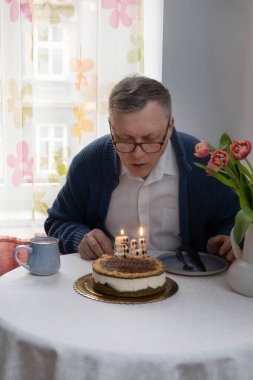 Adam doğum günü pastasında mumları üflüyor mutfakta tek başına.
