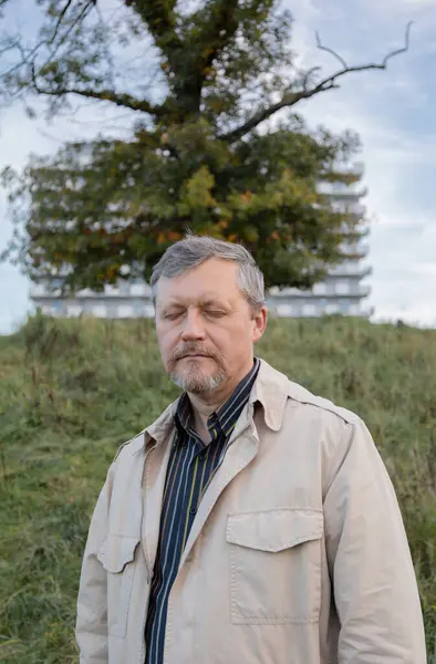 Açık havada gözleri kapalı olgun bir adam.