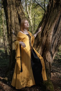 Ortaçağ elbiseli genç kadın bahar ormanında