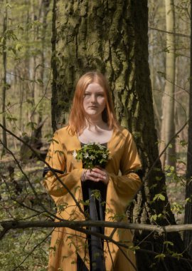 Ortaçağ elbiseli genç kadın bahar ormanında