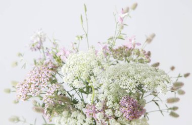 beyaz ve pembe kır çiçekleri arka planda beyaz duvar