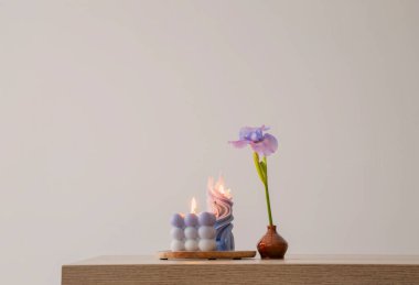 Ahşap masada yanan mumlarla mavi gözler.