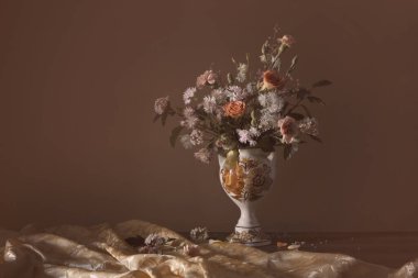 Koyu arkaplanda seramik vazoda yaz çiçekleri