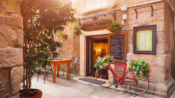 Tropea镇老房子里的街头餐馆Il Convivio 用花卉装饰的自行车装饰 免版税图库图片