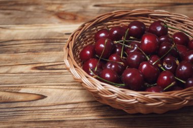 Etiketi koyu kırmızı kiraz dolu ahşap masa, altyazılar için telif alanı alanı