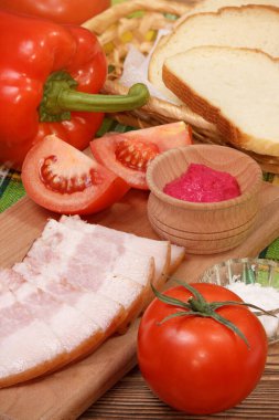 Taze sebzeli öğle yemeği ve tabakta dilimlenmiş domuz pastırması.