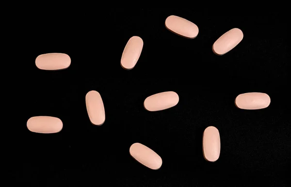 Píldoras Rosadas Dispersas Especificadas Sobre Fondo Negro — Foto de Stock
