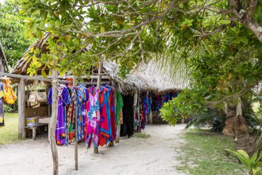 Malı ve turistleri Vanuatu 'daki Mystery Island' dan alışveriş yapan sazdan çatı sığınağı altındaki pazar