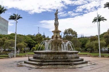 Celestial Fountain built in 1885 in centre of Coconut Place in the Central Gardens surrounded by trees and blue sky, Noumea, Grande Terre Island, New Caledonia clipart