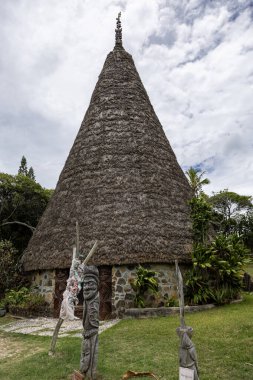 Geleneksel şef kulübesi sazdan çatılı ve Tinu Yarımadası, Noumea, Grande Terre Adası, Yeni Kaledonya 'da oyulmuş bir çatı mızrağı var.
